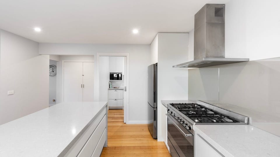 Fully equipped modern kitchen with stone benchtops and quality appliances