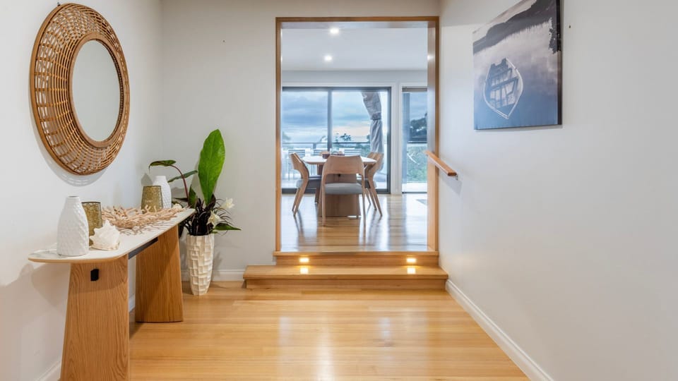 Spacious entry and hallway with warm timber flooring