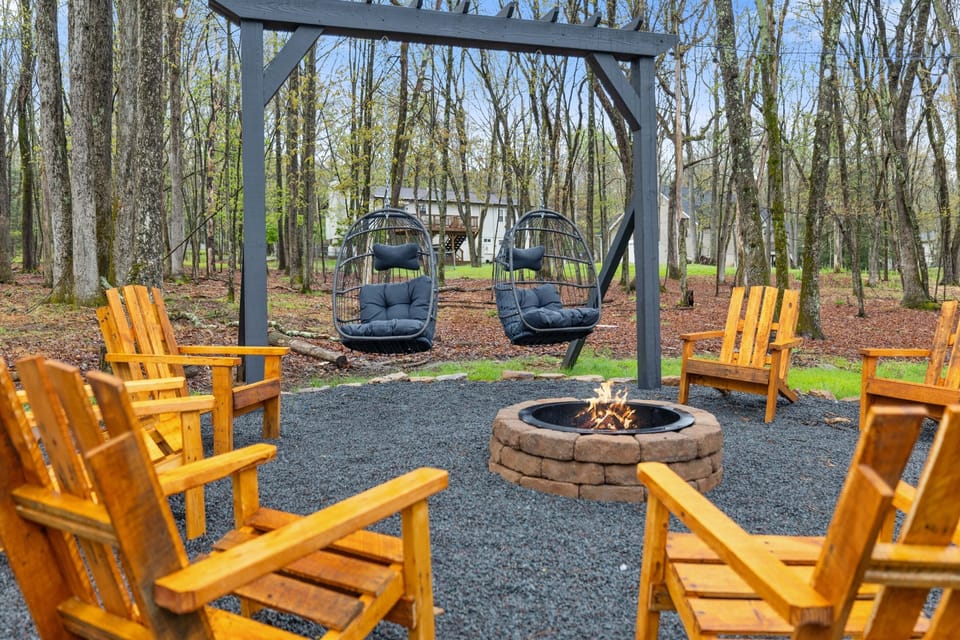 Fire pit area with Adirondack chairs and an egg chair swing pergola 