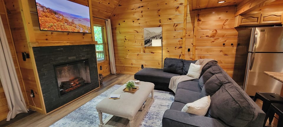 Cozy cabin living room with fireplace, TV, and plush sectional seating