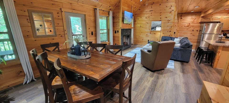 Cozy open-concept cabin with fireplace, dining space, and bar seating
