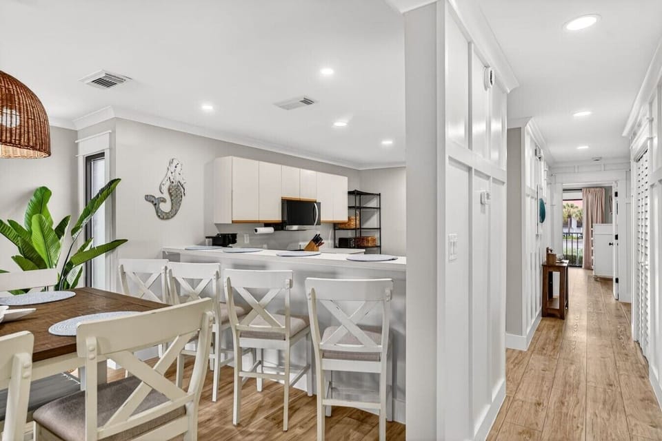 Coastal-inspired dining area with breakfast bar seating and a bright, airy layout.