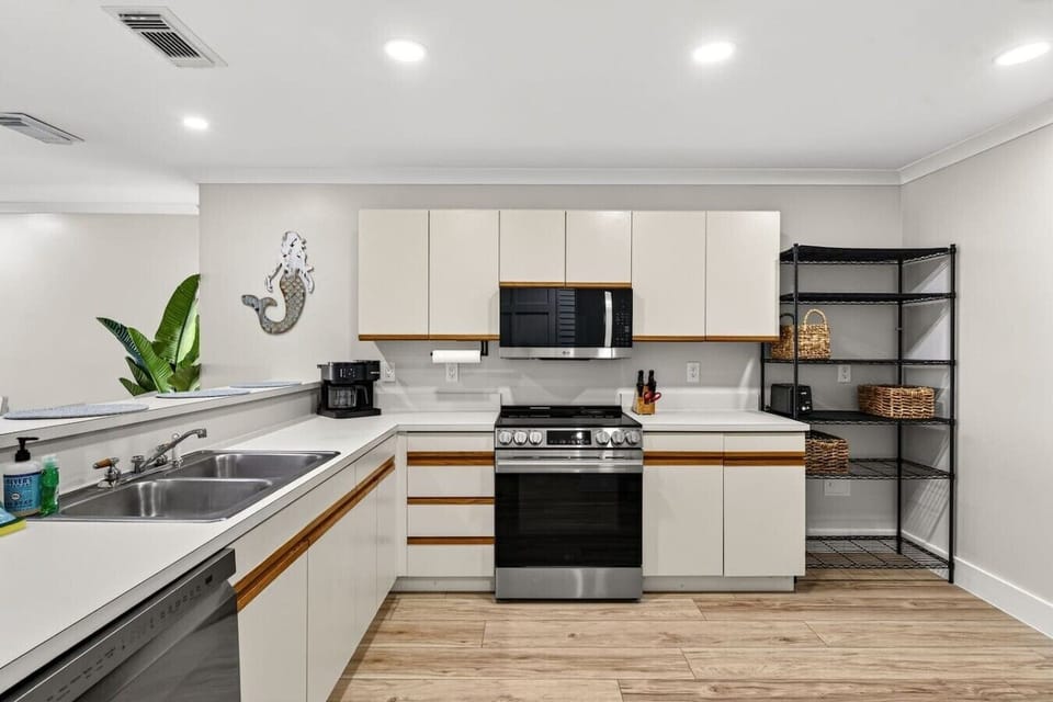Fully equipped kitchen with modern stainless steel appliances and ample counter space for preparing vacation meals.