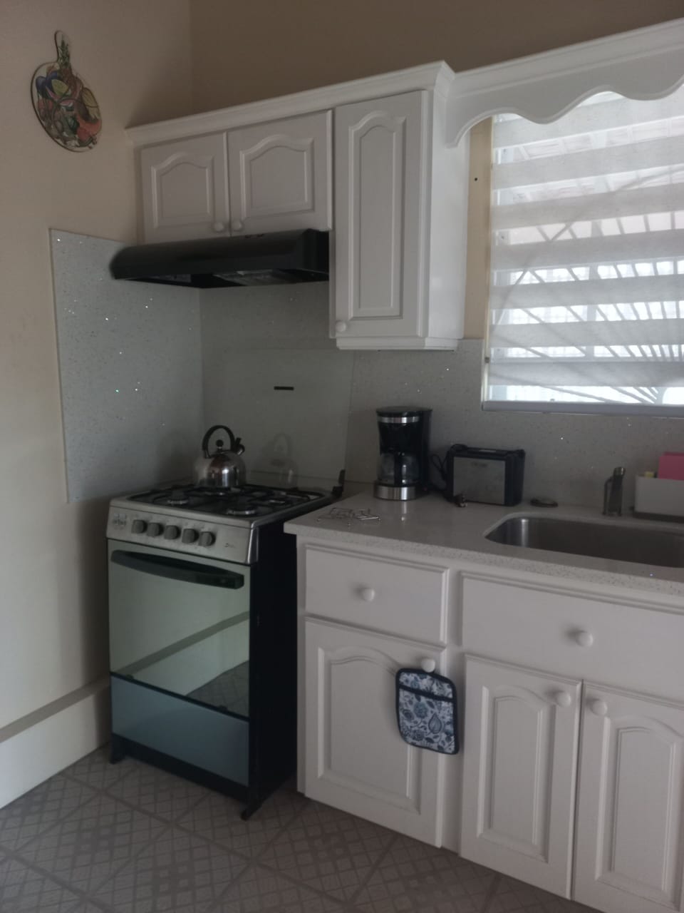 Kitchen equipped with coffeemaker, gas stove, refridgerator, and pantry