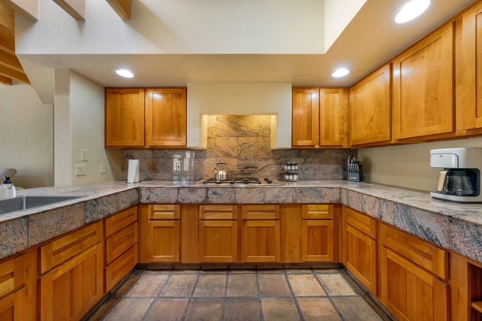 Fully equipped kitchen with gas cooktop, drip coffee maker, and plenty of storage space