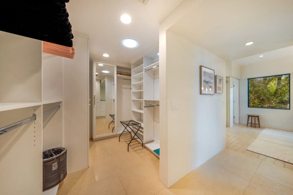Large walk-in closet with custom storage, mirrored wardrobes, and plenty of room to settle in