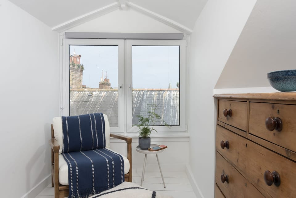 Seating within master bedroom with coffee table and large window - Bluebell Cottage