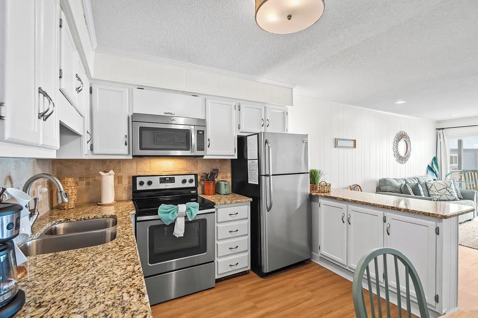 Bright open kitchen with granite counters and stainless steel appliances