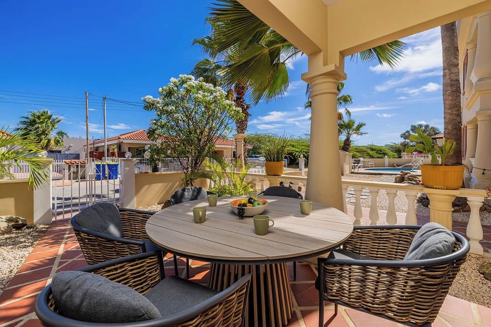 Inviting outdoor patio with stylish tilework and shaded seating, perfect for relaxing, enjoying a morning coffee, or unwinding after a day in the sun