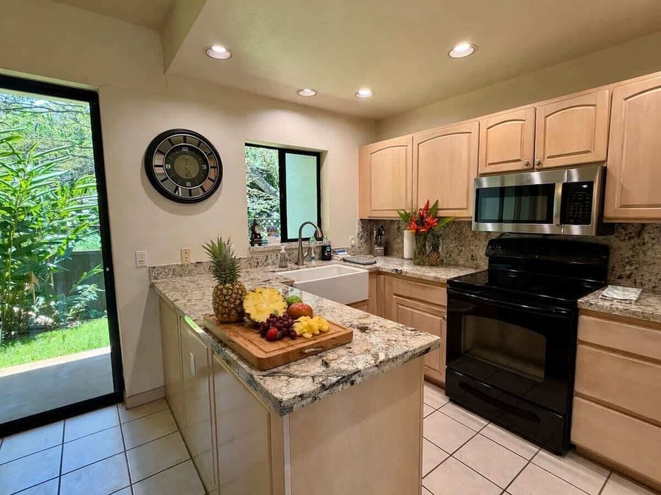 Bright, fully equipped kitchen with granite countertops, modern appliances, and tropical garden views. Prepare meals with ease, then relax in cool, refreshing A/C after a fun day exploring Maui’s beautiful beaches and island adventures.