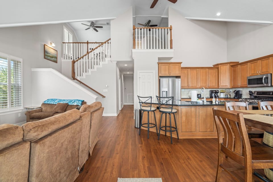 Gather with ease in this spacious open-concept living area featuring soaring ceilings, a full kitchen, and plenty of room to relax.