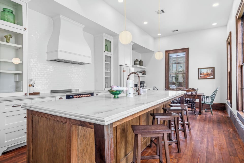 Bright, chef-style kitchen with a spacious marble island, custom cabinetry, and inviting dining space for gathering.