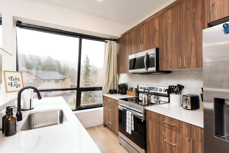 Kitchen is equipped with fridge, oven, microwave, and dishwasher. 