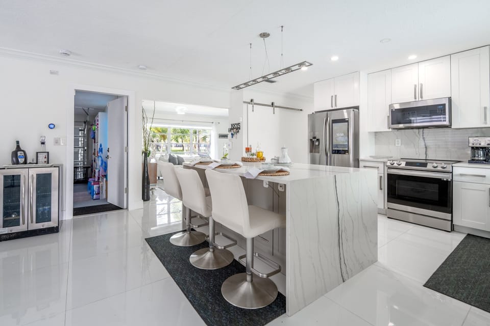 Modern chef kitchen with waterfall island & stainless appliances