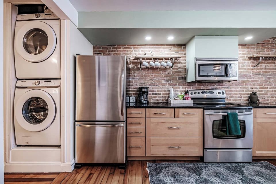 Cook with ease in the stylish kitchen featuring exposed brick and stainless steel appliances.