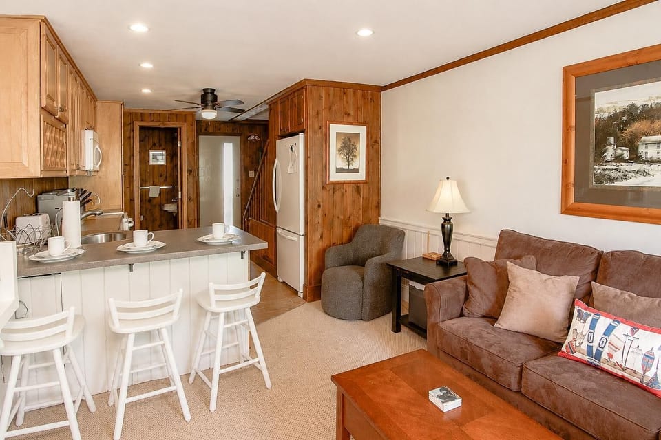 Unwind in the inviting living room, where a charming wood-burning stove creates the perfect setting for cozy evenings after a day of mountain adventures.