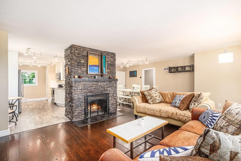 Stone fireplace at the center of open flow - living room, dining room and kitchen.