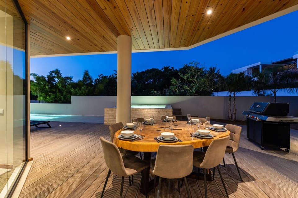 Covered outdoor dining area with seating for the whole group, perfect for al fresco meals beside the pool.