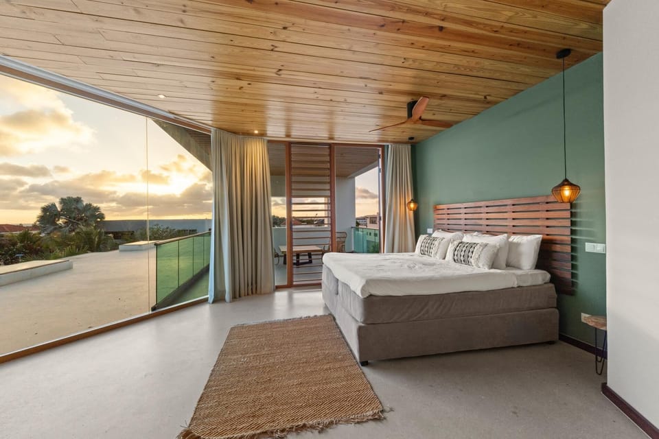 The spacious primary suite features a king bed, private sitting deck and direct access to the rooftop terrace with panoramic island and ocean views.
