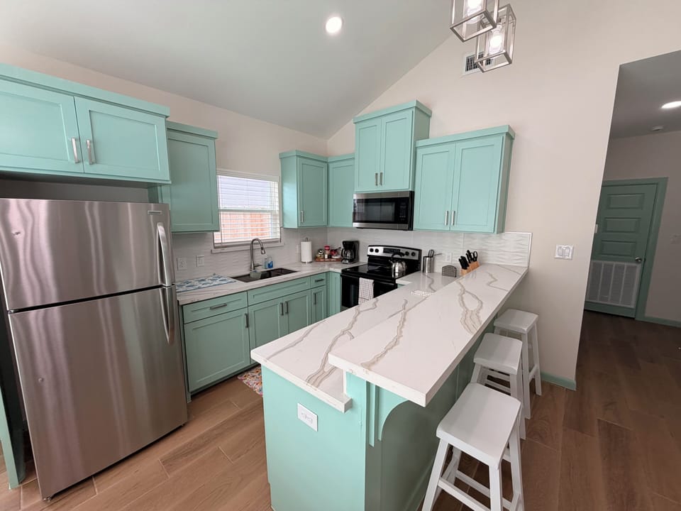 Bright modern kitchen with breakfast bar and stylish mint cabinets