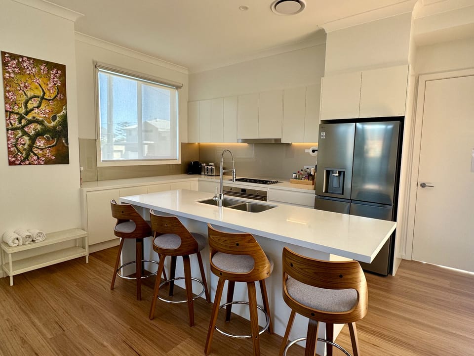 Bright modern kitchen with island seating for four and sleek finishes