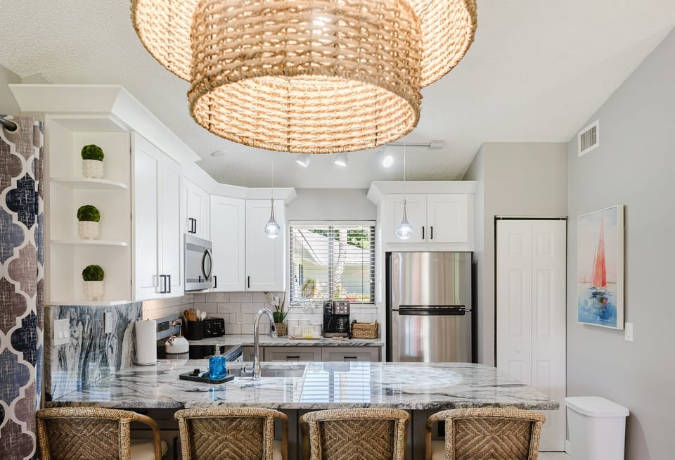 Bright open-concept living with dining for 6 and a fully upgraded kitchen featuring modern finishes, breakfast bar seating, and everything you need to cook and entertain