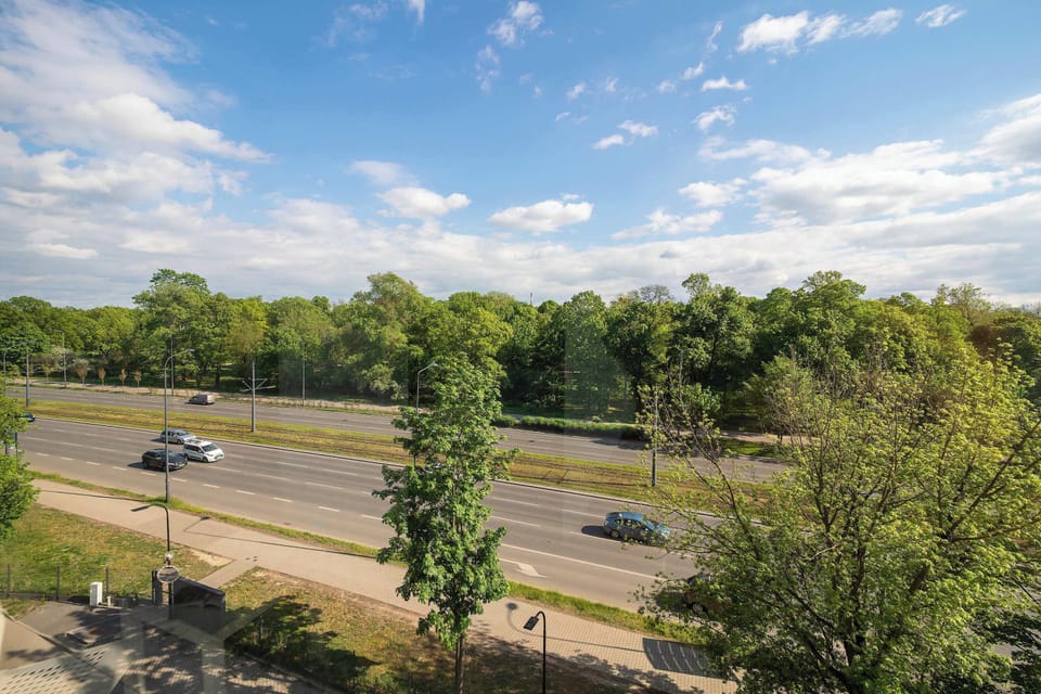 A balcony view overlooking greenery and open space. It offers a peaceful atmosphere.