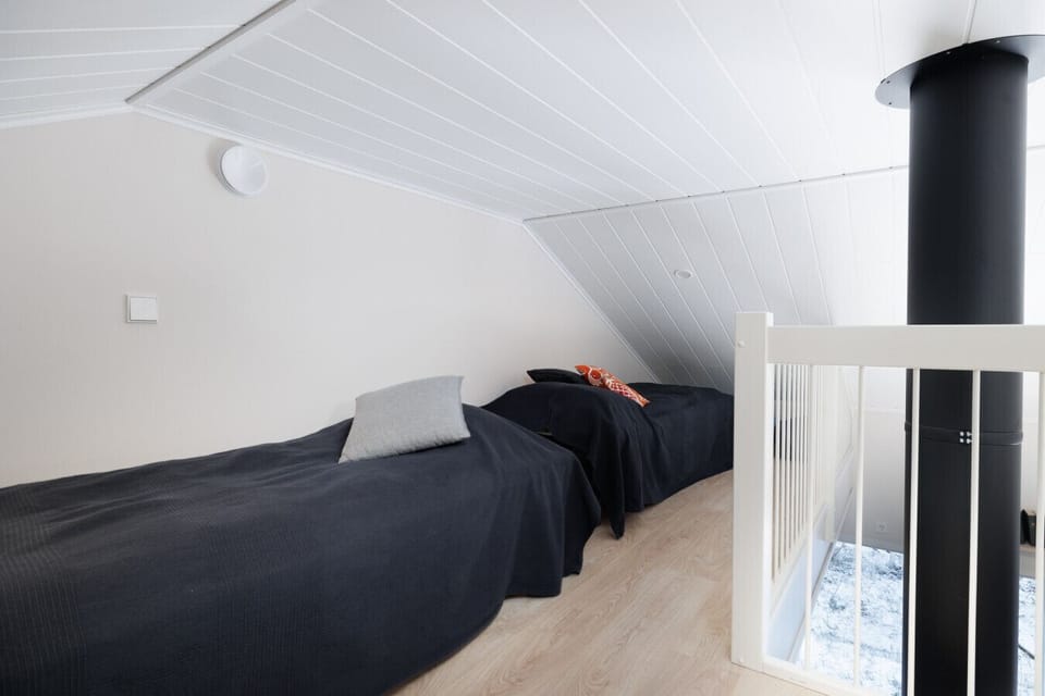 Our upstairs loft is equipped with two additional twin beds, making it an ideal space for families traveling with teenagers or groups of friends. Despite the sloping ceiling, the area feels bright and airy thanks to the open-plan design and white wood fin