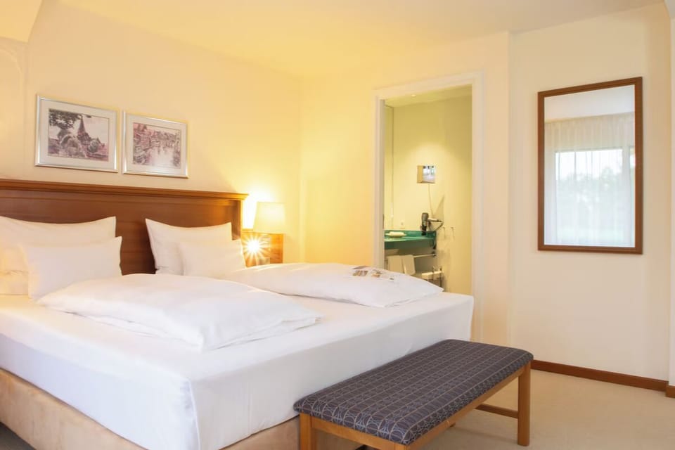 Drift off in crisp linens under soft bedside glow.