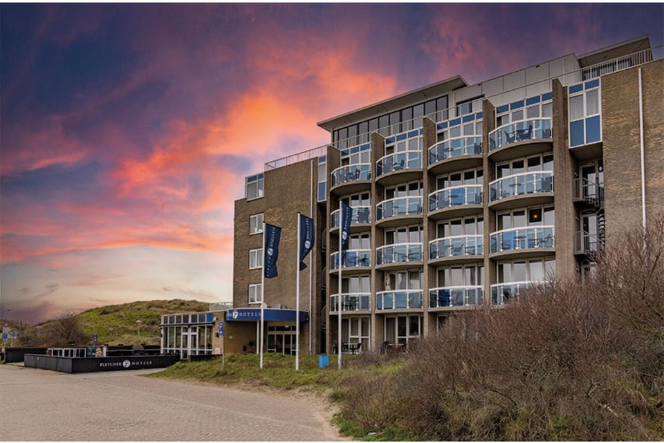Arrive at a seaside hotel glowing under vibrant sunsets.