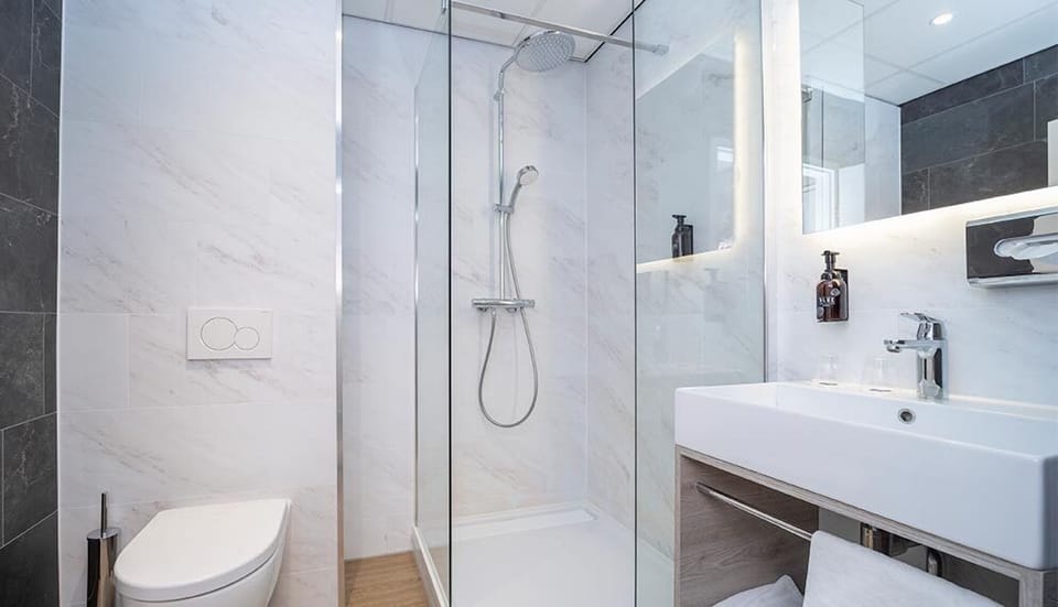 Refresh under a sleek glass shower in a spotless bath.