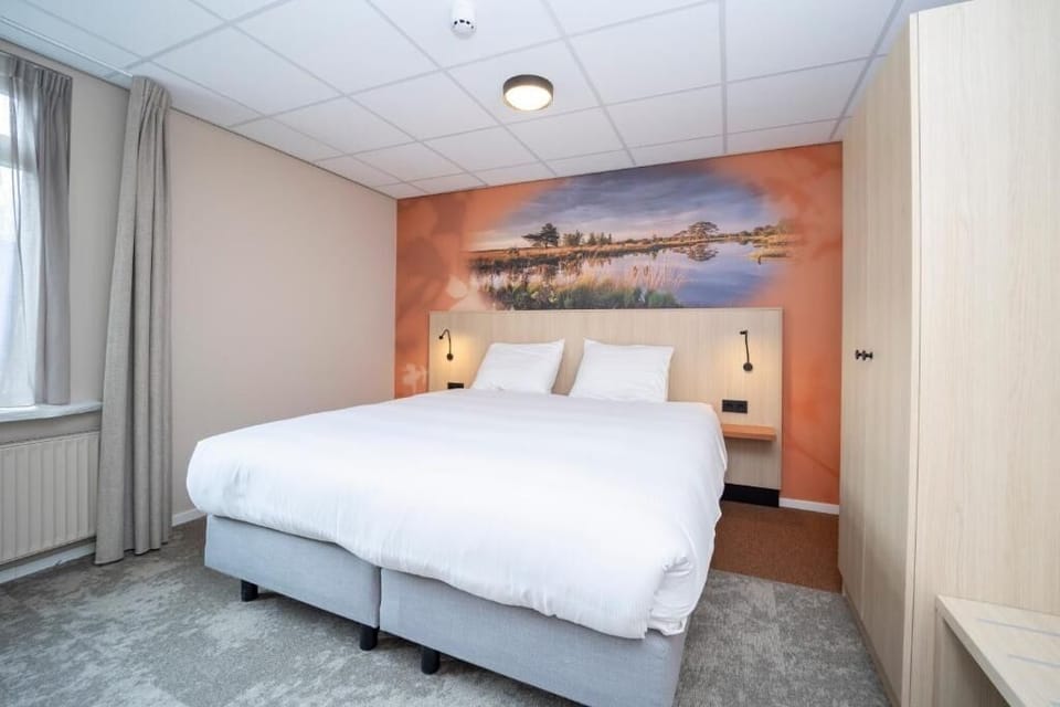 Sink into crisp linens beneath calming landscape wall art.