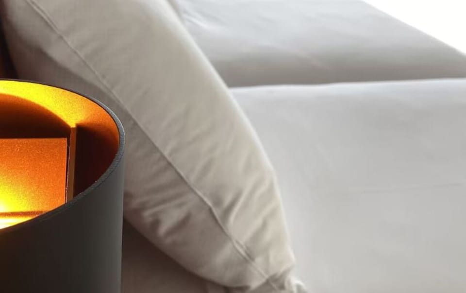 Relax beside warm ambient lighting and freshly pressed bedding.