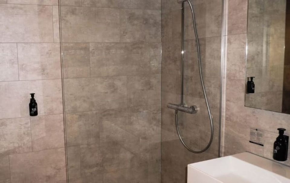 Refresh under a sleek walk-in shower in modern tiles.