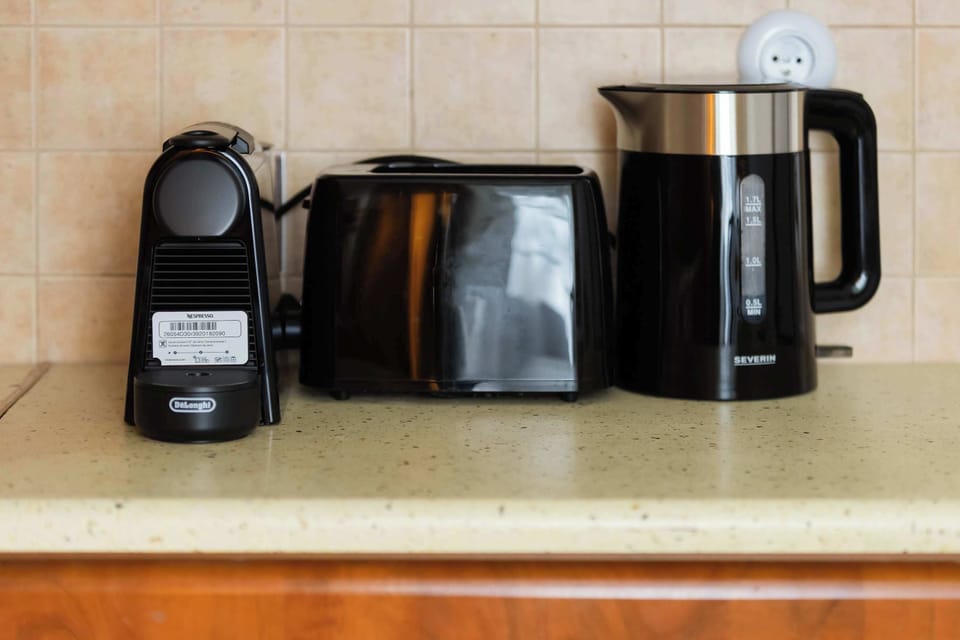 A close-up of kitchen appliances including a coffee machine, toaster, and kettle.