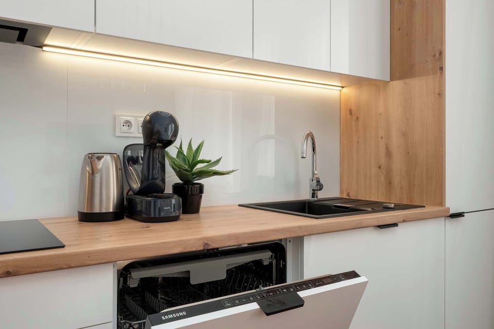 A detailed look at a kitchen counter with under-cabinet lighting and neatly arranged utensils.