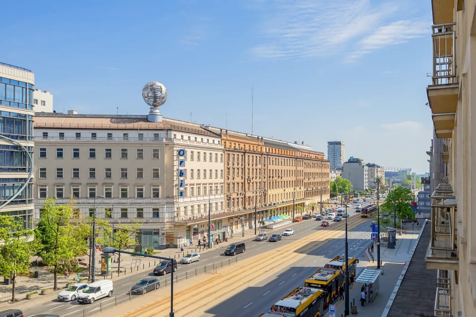 A wide city panorama featuring historic architecture and traffic-filled avenues.