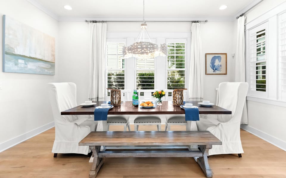 The dining area comfortably seats eight guests under chandelier lighting