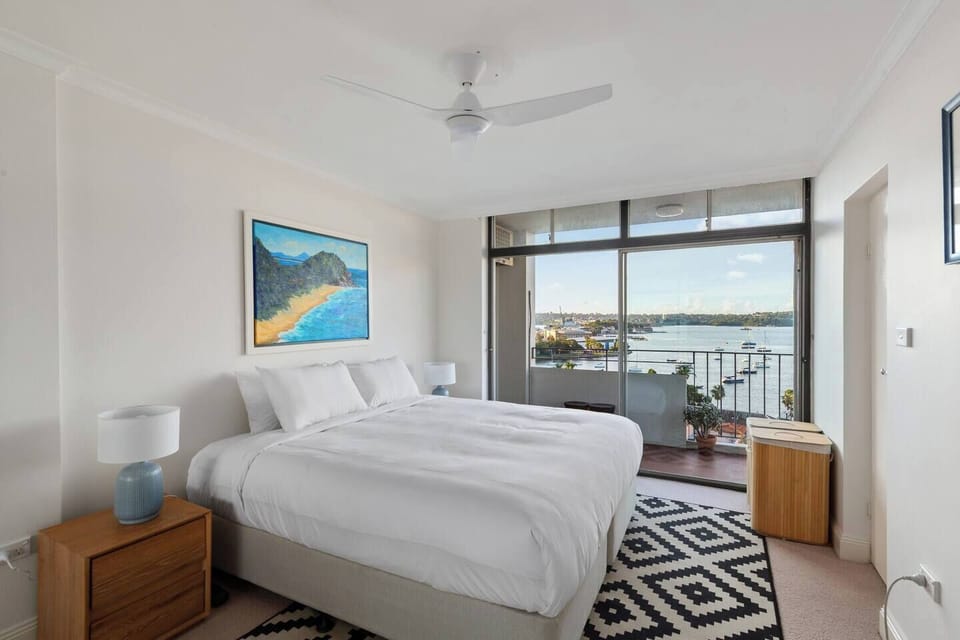 Wake to sparkling water views from the primary bedroom, where a king bed and direct balcony access create a calm retreat above the harbour.
