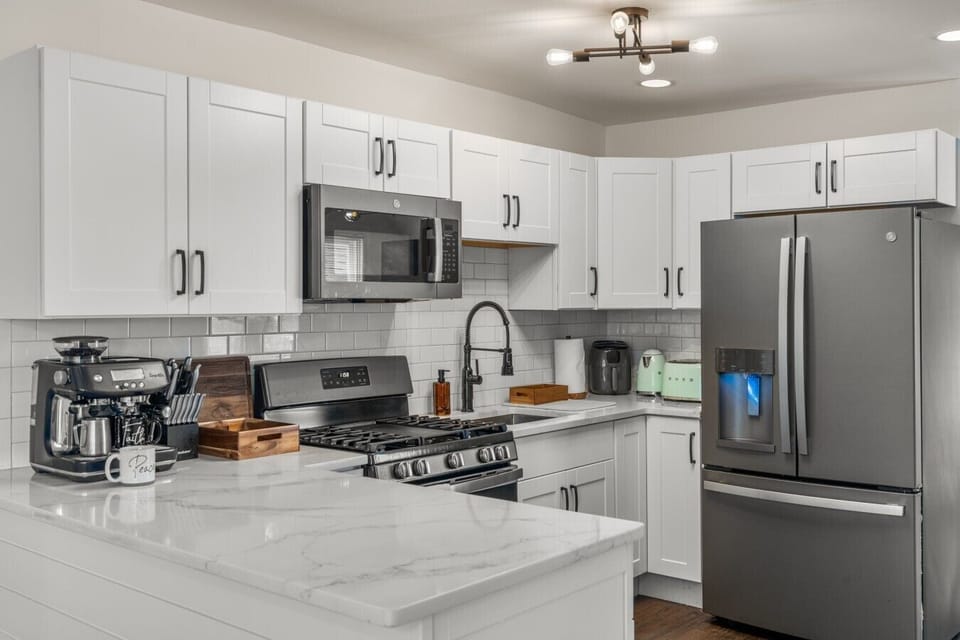 Beautifully renovated and fully stocked kitchen with quartz countertops, brand new matte slate appliances, and everything needed for meals at home