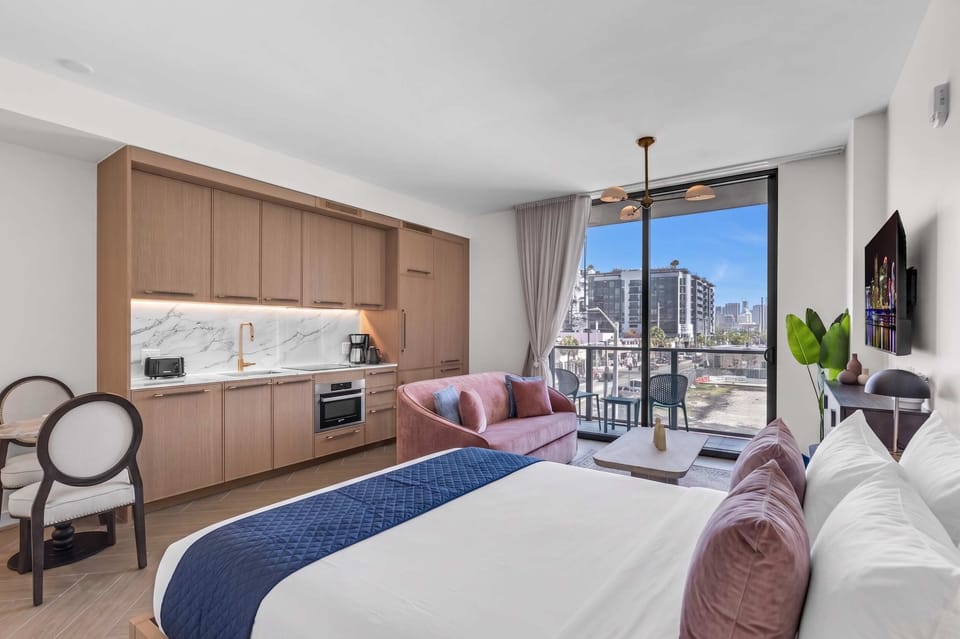 Modern studio in the heart of Wynwood with skyline views from your private balcony. Sleek kitchenette, plush king bed, cozy sitting area, and a small dining table with 2 chairs—everything you need for the perfect Miami stay. 