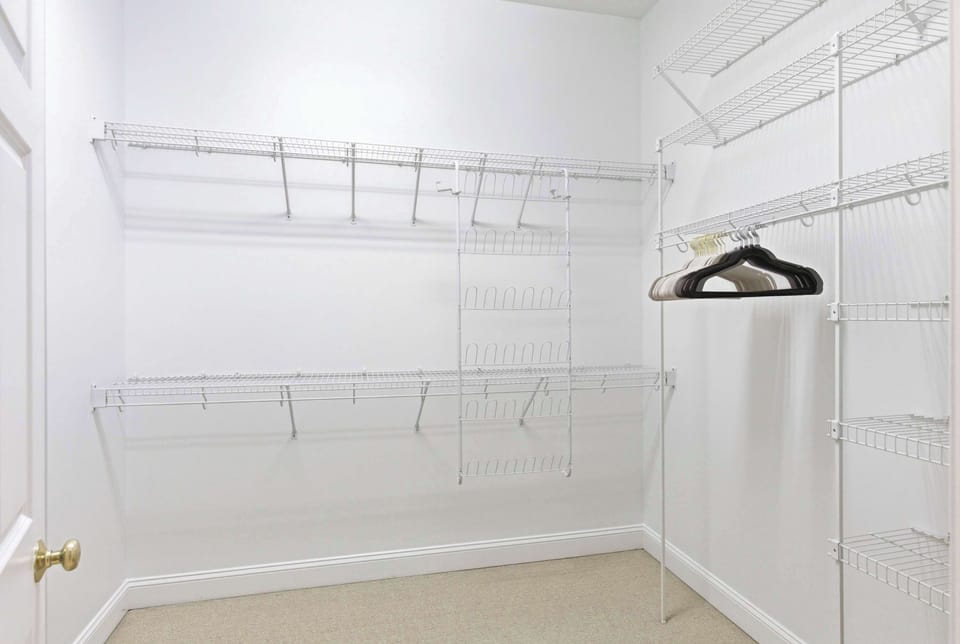 Spacious walk-in closet with a full wire shelving system — plenty of room for a week of beach outfits and more.