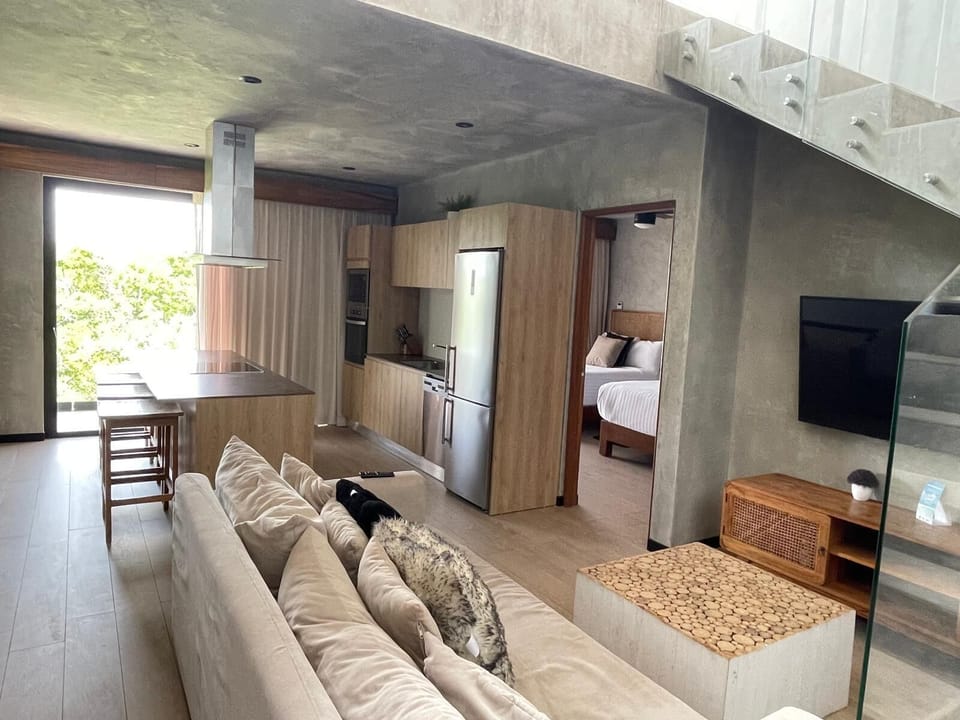 View from entry door into living room and kitchen. Stairs to the right go up one