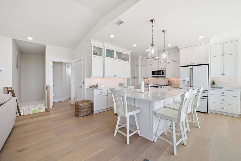 Modern Kitchen w/  Refrigerator, Built-In Microwave, Stove, Sink,  Oven, Dishwasher, Cooking Utensils, and Island Seating