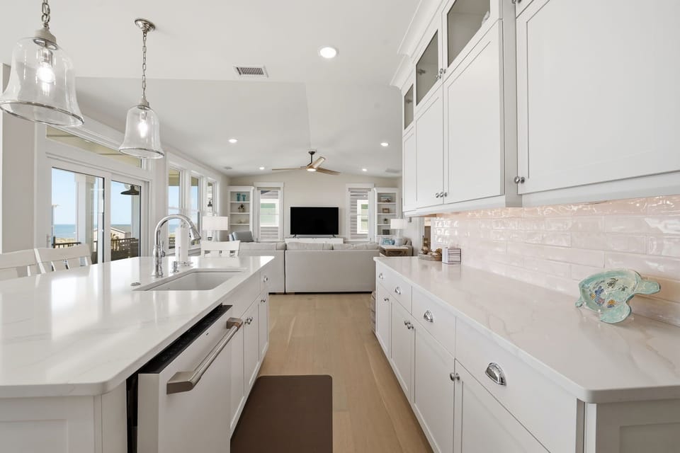 Modern Kitchen w/  Refrigerator, Built-In Microwave, Stove, Sink,  Oven, Dishwasher, Cooking Utensils, and Island Seating