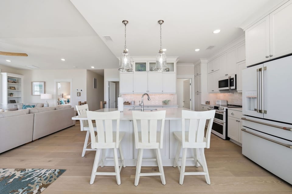 Modern Kitchen w/  Refrigerator, Built-In Microwave, Stove, Sink,  Oven, Dishwasher, Cooking Utensils, and Island Seating