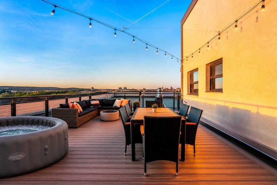 Spacious rooftop with separate lounge, hot tub, and dining areas for group use.