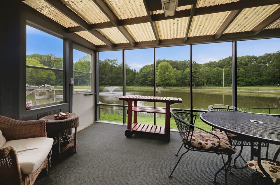Dine or unwind on the screened porch overlooking the peaceful pond.