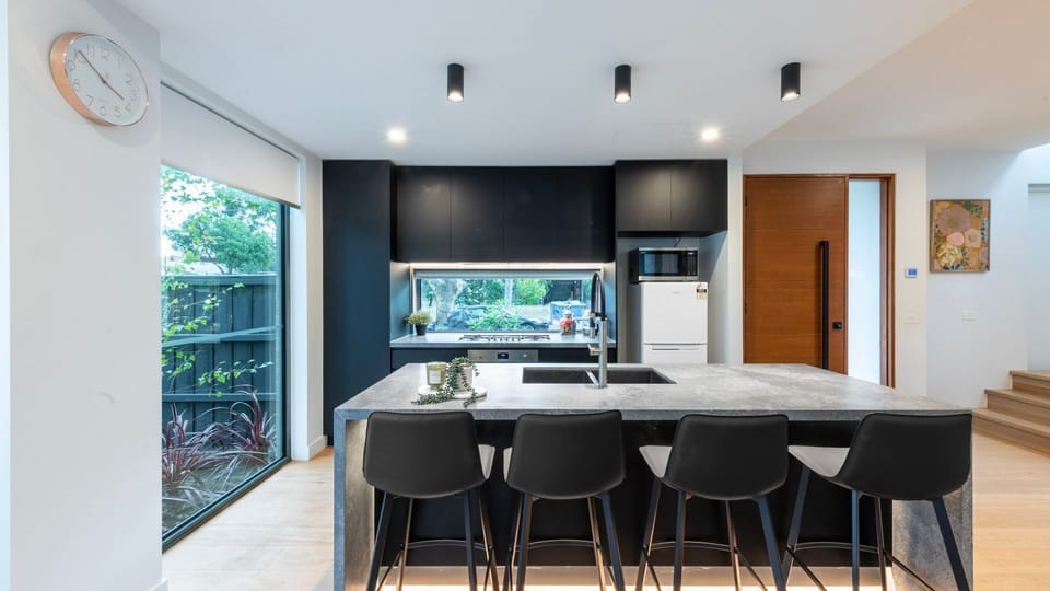 Modern entertainer’s kitchen with breakfast bar, sleek finishes and garden outlook