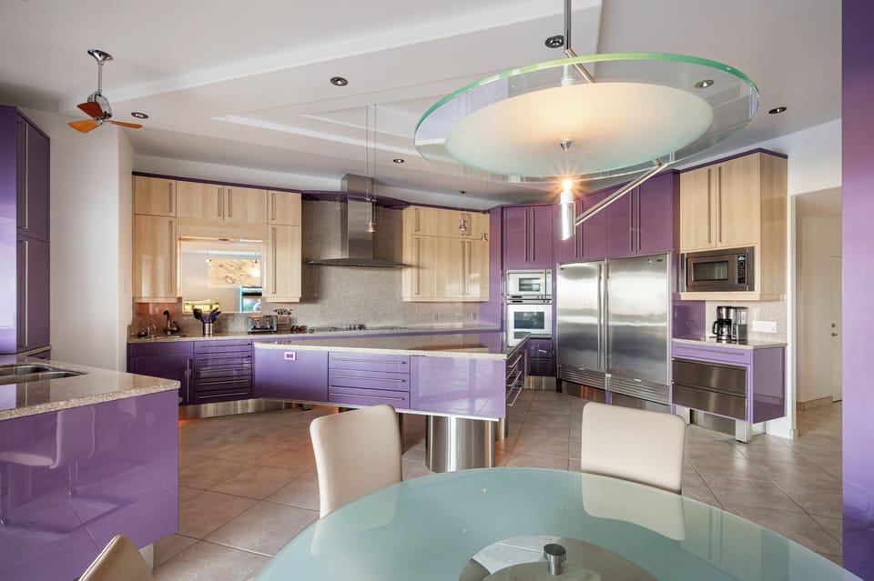 The chef's kitchen makes a striking statement with custom high-gloss cabinetry, premium stainless steel appliances, expansive prep space, and sleek contemporary design tailored for both everyday living and entertaining.